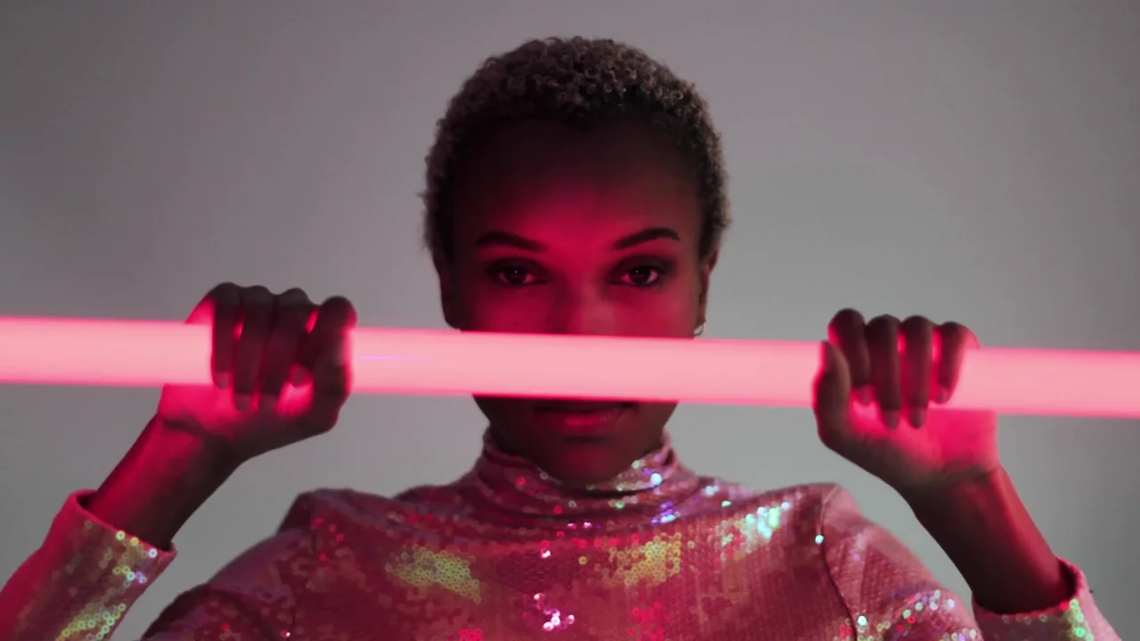 A creative portrait lit by a pink studio light